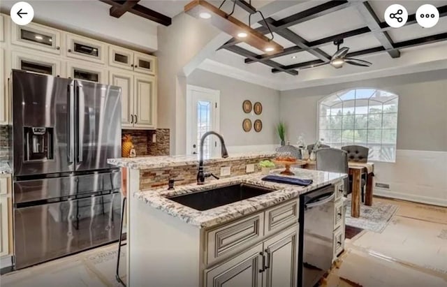 kitchen featuring a sink, a wealth of natural light, coffered ceiling, stainless steel appliances, and a kitchen island with sink