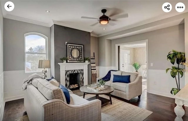 living room with wood finished floors, a high end fireplace, and ornamental molding