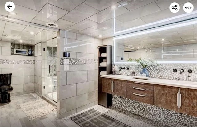 full bath featuring double vanity and a shower with shower door