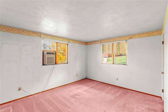 empty room with baseboards, carpet floors, and a wall unit AC