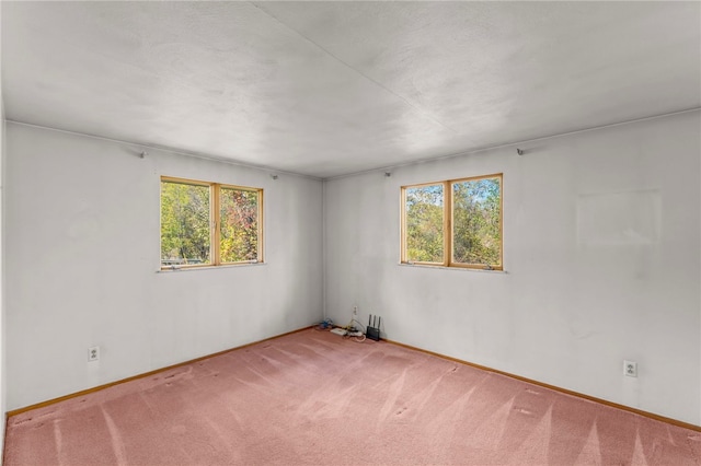 unfurnished room with baseboards, plenty of natural light, and carpet