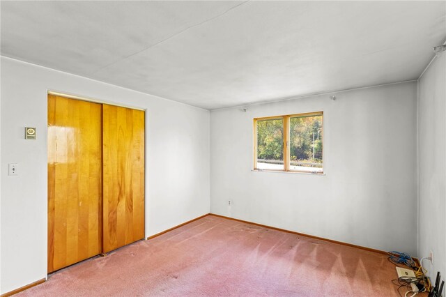 unfurnished bedroom featuring a closet, baseboards, and carpet