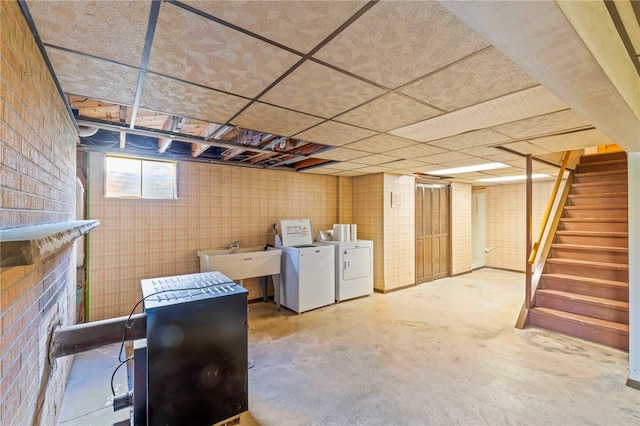 below grade area with washer and dryer, stairway, a fireplace, and a sink