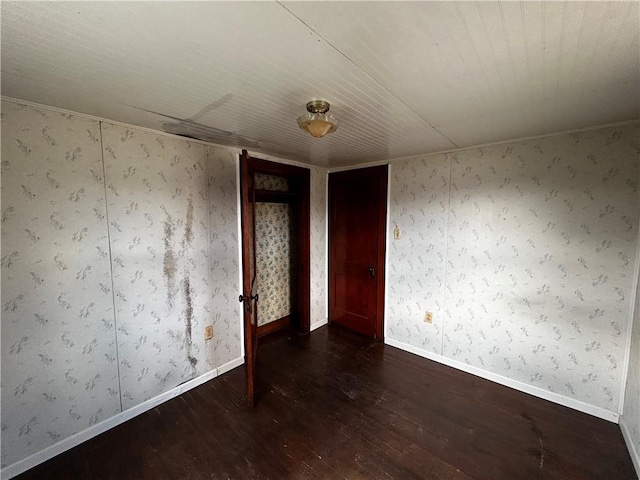 unfurnished room with baseboards and wood finished floors