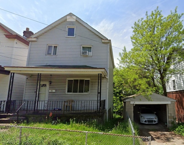 view of front facade with a porch, fence, and a detached garage