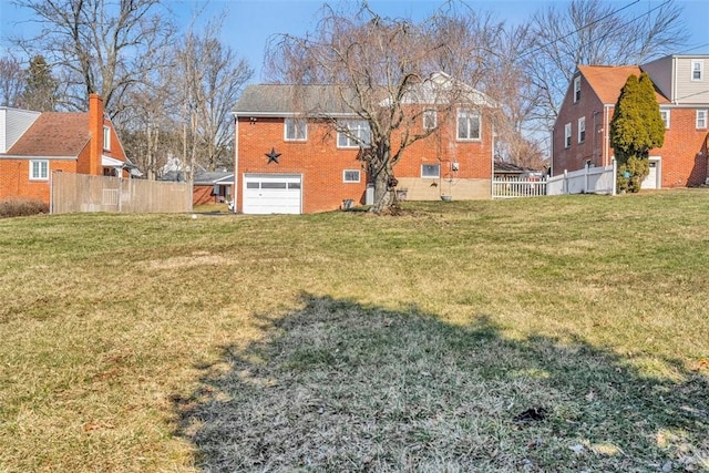 view of yard with an attached garage and fence