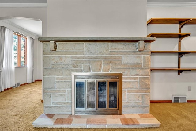 room details featuring a stone fireplace, visible vents, and carpet floors