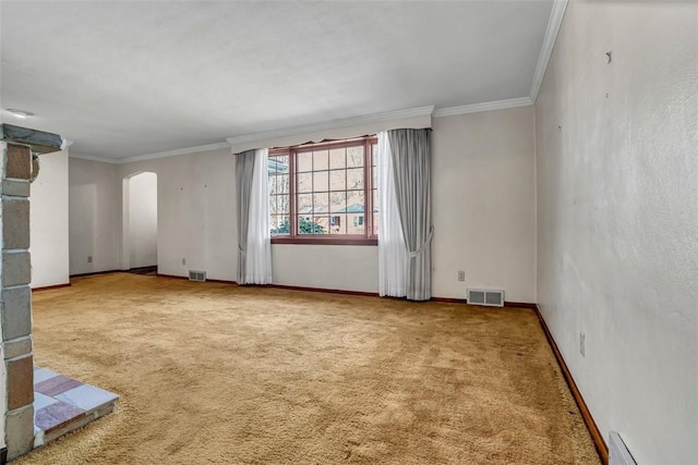 spare room with visible vents, ornamental molding, carpet flooring, baseboard heating, and arched walkways