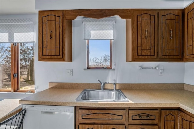 kitchen featuring a sink, plenty of natural light, dishwasher, and brown cabinetry