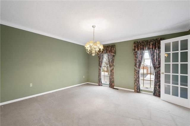 spare room with baseboards, an inviting chandelier, carpet flooring, and crown molding