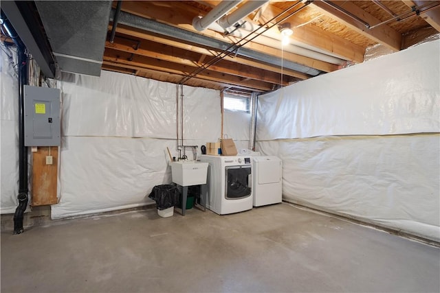 below grade area featuring electric panel, a sink, and washer and clothes dryer