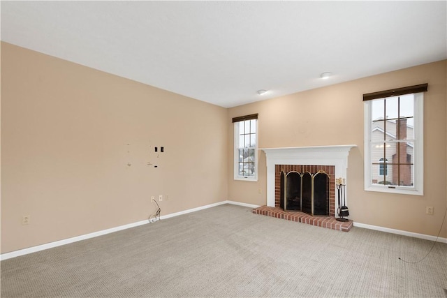 unfurnished living room featuring a fireplace, carpet, and baseboards