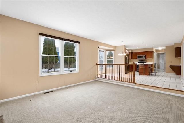 spare room with visible vents, baseboards, recessed lighting, light carpet, and a notable chandelier