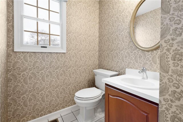 half bathroom with toilet, vanity, and tile patterned flooring