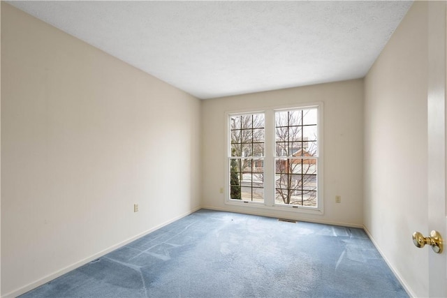 spare room with visible vents, baseboards, carpet floors, and a textured ceiling