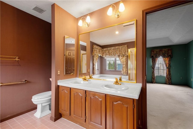 full bathroom with double vanity, toilet, visible vents, and a sink