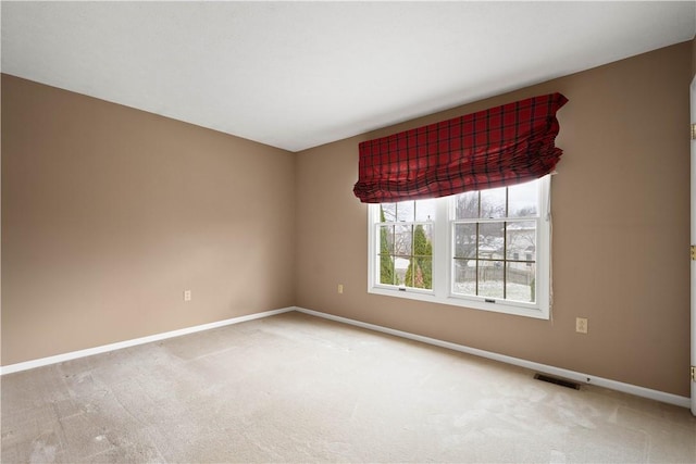 carpeted spare room featuring visible vents and baseboards