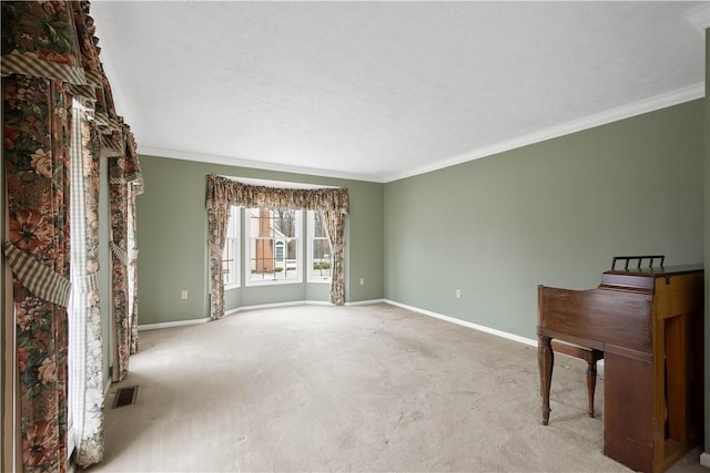 spare room featuring visible vents, ornamental molding, baseboards, and carpet floors