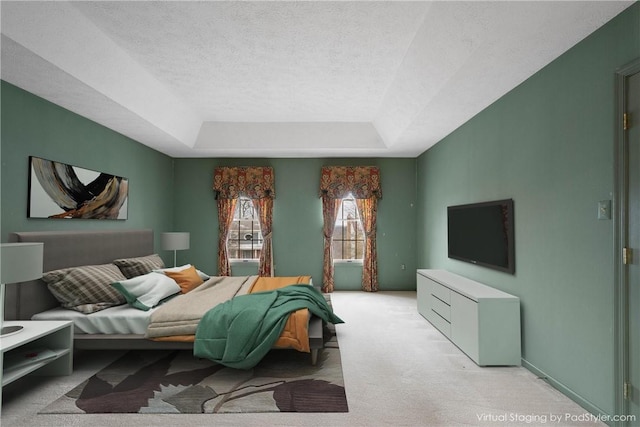 bedroom with a tray ceiling, light carpet, and a textured ceiling