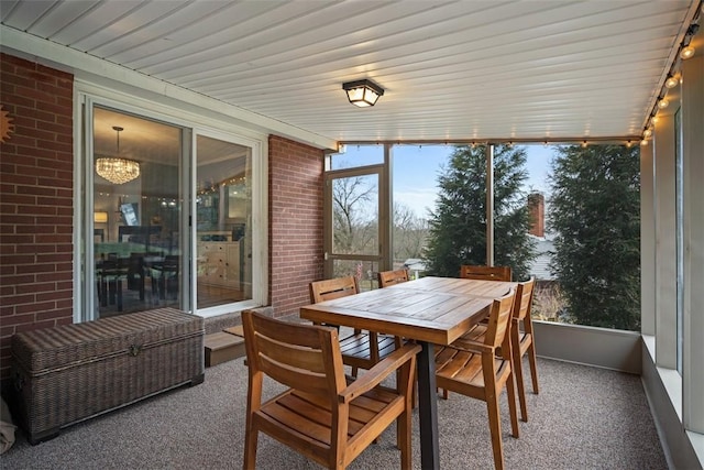 sunroom / solarium featuring an inviting chandelier