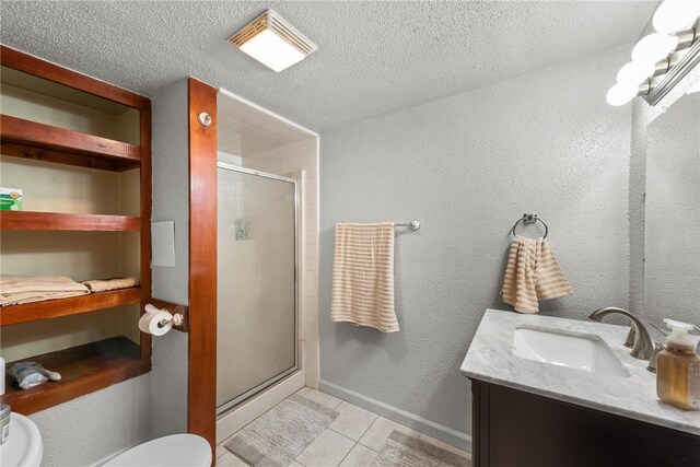 bathroom with a shower stall, toilet, vanity, tile patterned floors, and a textured ceiling