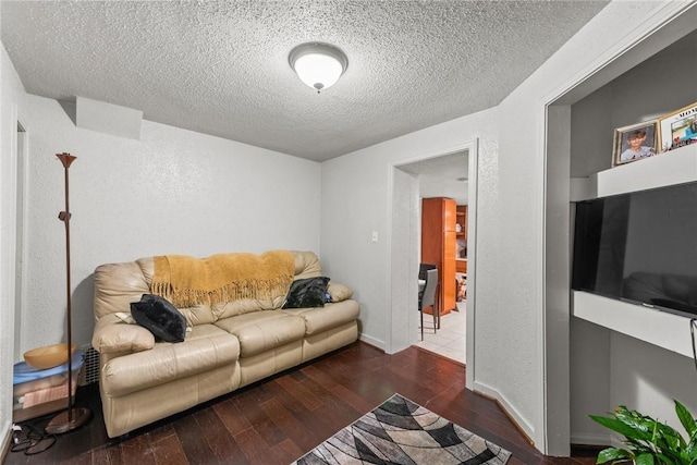 living room with baseboards, a textured ceiling, wood finished floors, and a textured wall