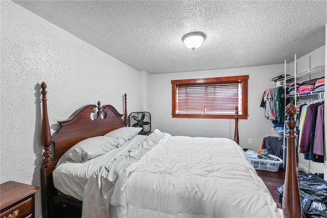 bedroom featuring a textured wall and a textured ceiling