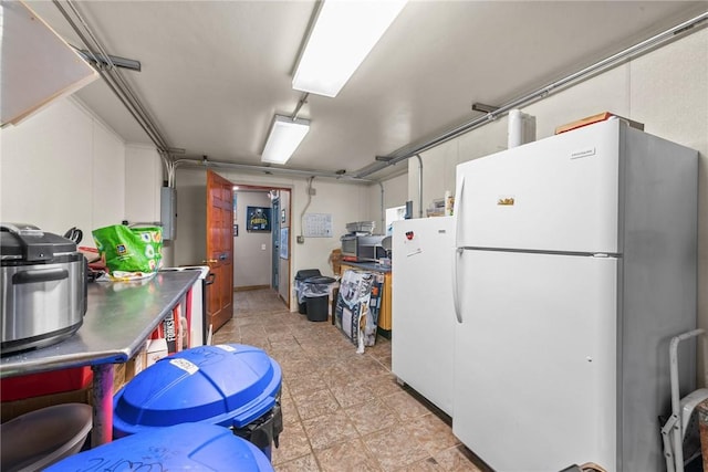 kitchen featuring white cabinets and freestanding refrigerator