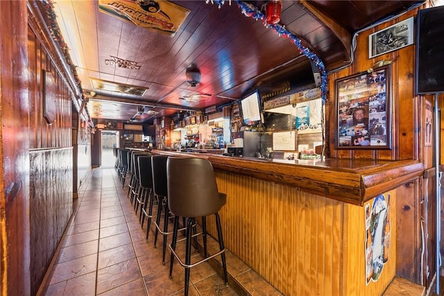 bar featuring wood walls, a dry bar, and wood ceiling