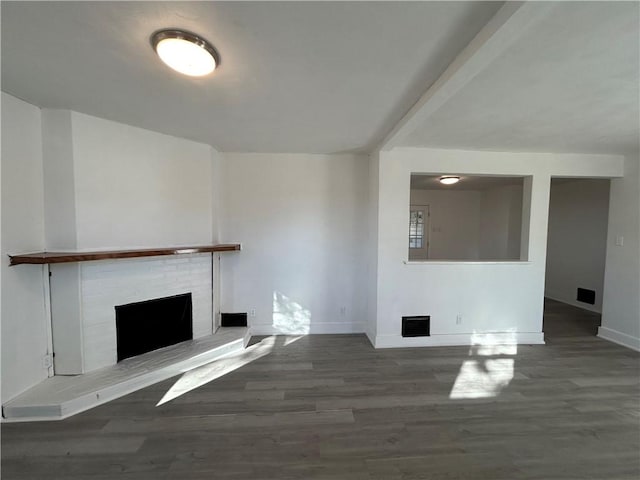 unfurnished living room with visible vents, a brick fireplace, baseboards, and wood finished floors