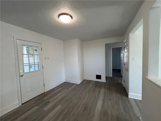 interior space with baseboards and dark wood-style floors