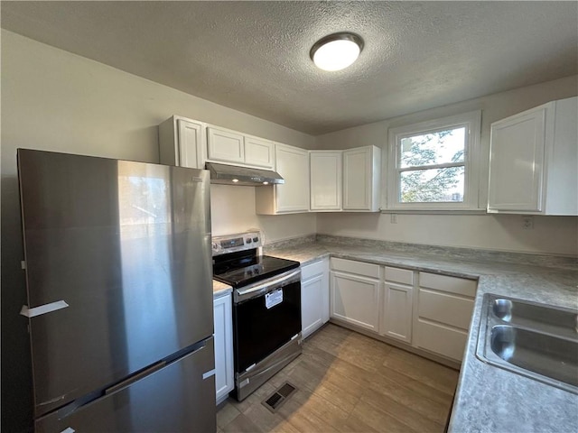 kitchen with visible vents, under cabinet range hood, light countertops, white cabinets, and stainless steel appliances