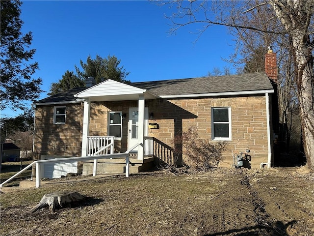 view of front of house with a chimney and a shingled roof