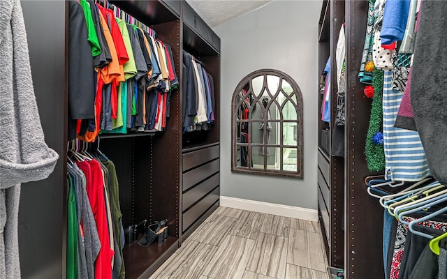 walk in closet with wood finished floors