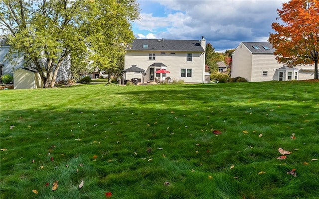 back of house with a gazebo and a yard