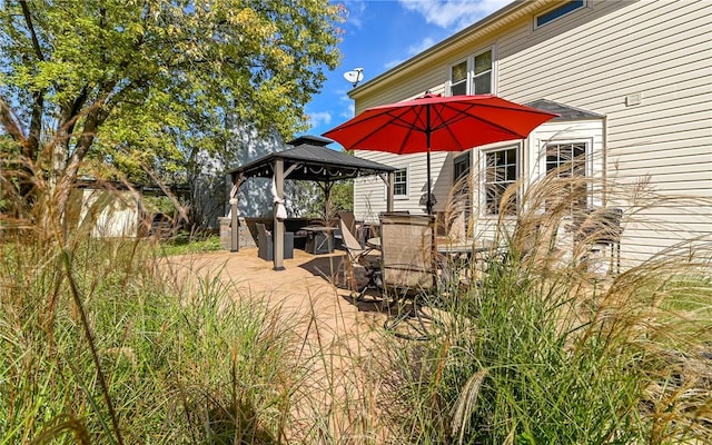 deck with a gazebo, outdoor dining space, and a patio area