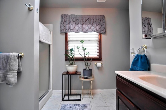 bathroom with tile patterned floors, a shower stall, vanity, and baseboards