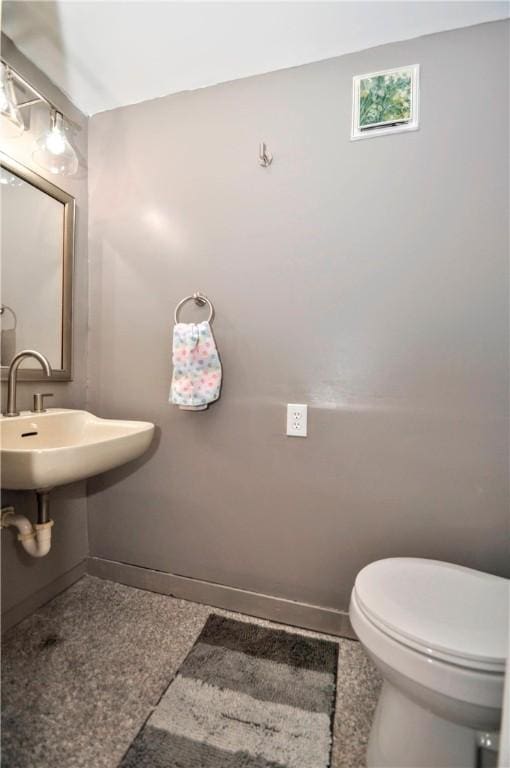 half bath featuring toilet and baseboards
