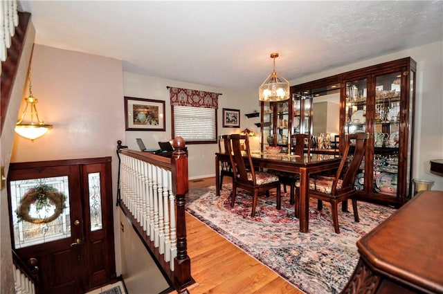 dining space with wood finished floors and a chandelier