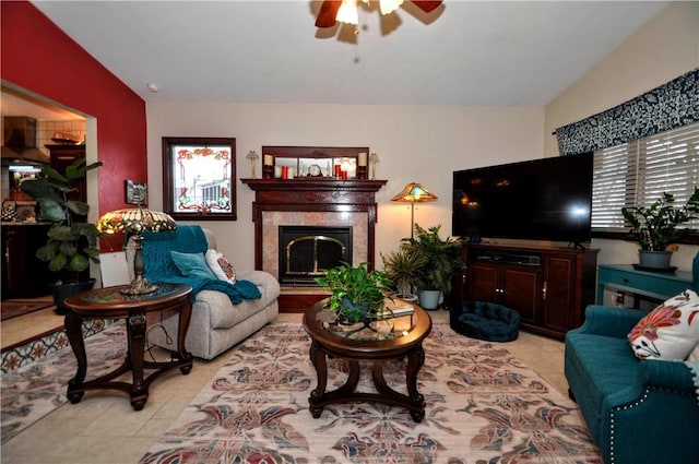 living room with a fireplace, lofted ceiling, a ceiling fan, and light tile patterned floors