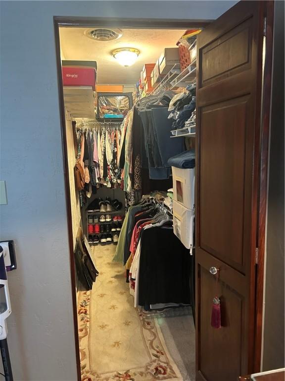 walk in closet featuring carpet floors