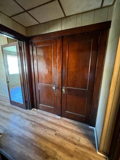 hall with wood walls and light wood finished floors