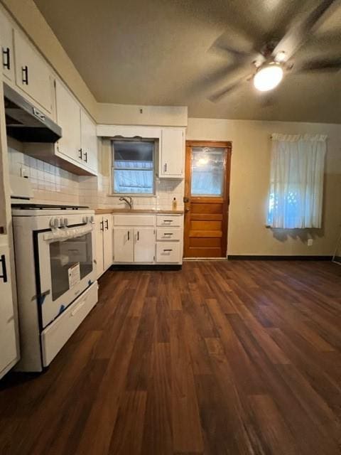 kitchen with white range with gas cooktop, under cabinet range hood, tasteful backsplash, dark wood-style floors, and white cabinetry