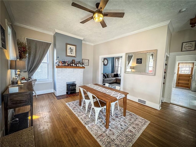 dining space featuring visible vents, ornamental molding, and hardwood / wood-style flooring