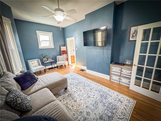 sitting room featuring visible vents, baseboards, a ceiling fan, and wood finished floors