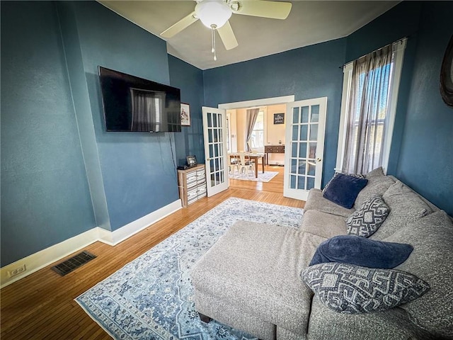 sitting room with wood finished floors, french doors, visible vents, and a wealth of natural light