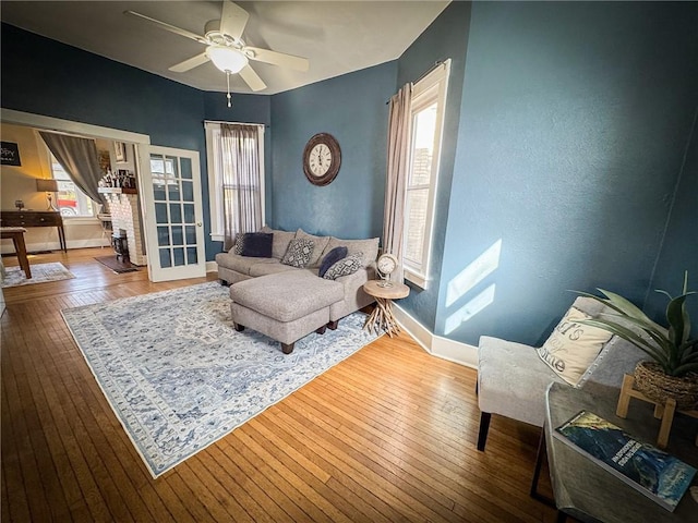 living room featuring a ceiling fan, baseboards, and hardwood / wood-style floors