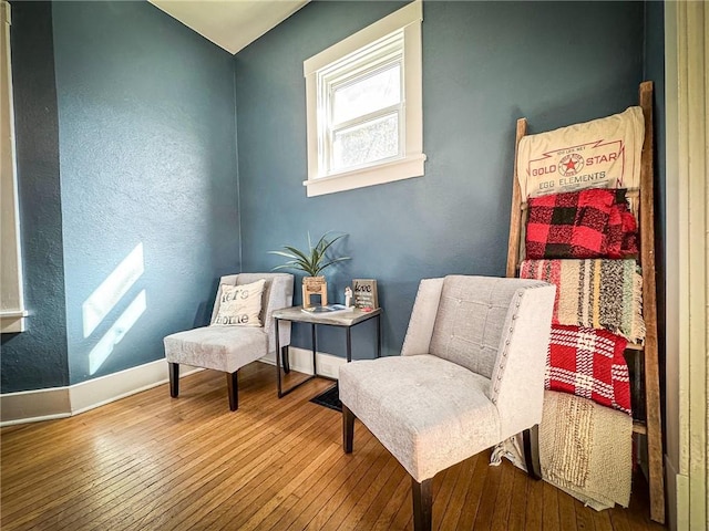 living area with hardwood / wood-style flooring and baseboards