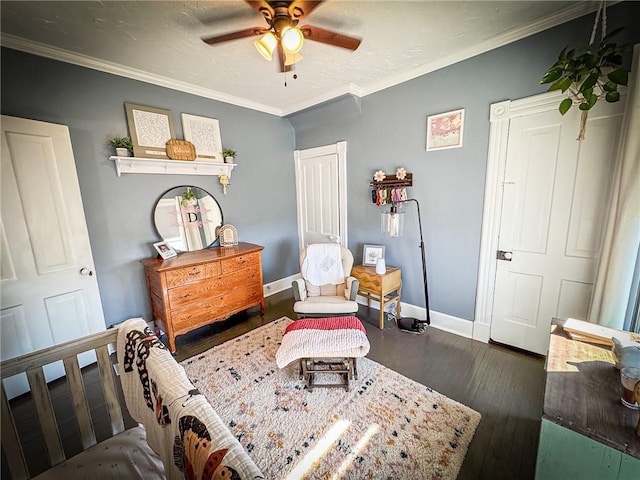 sitting room with dark wood finished floors, ceiling fan, crown molding, and baseboards