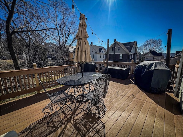 deck featuring outdoor dining space and grilling area